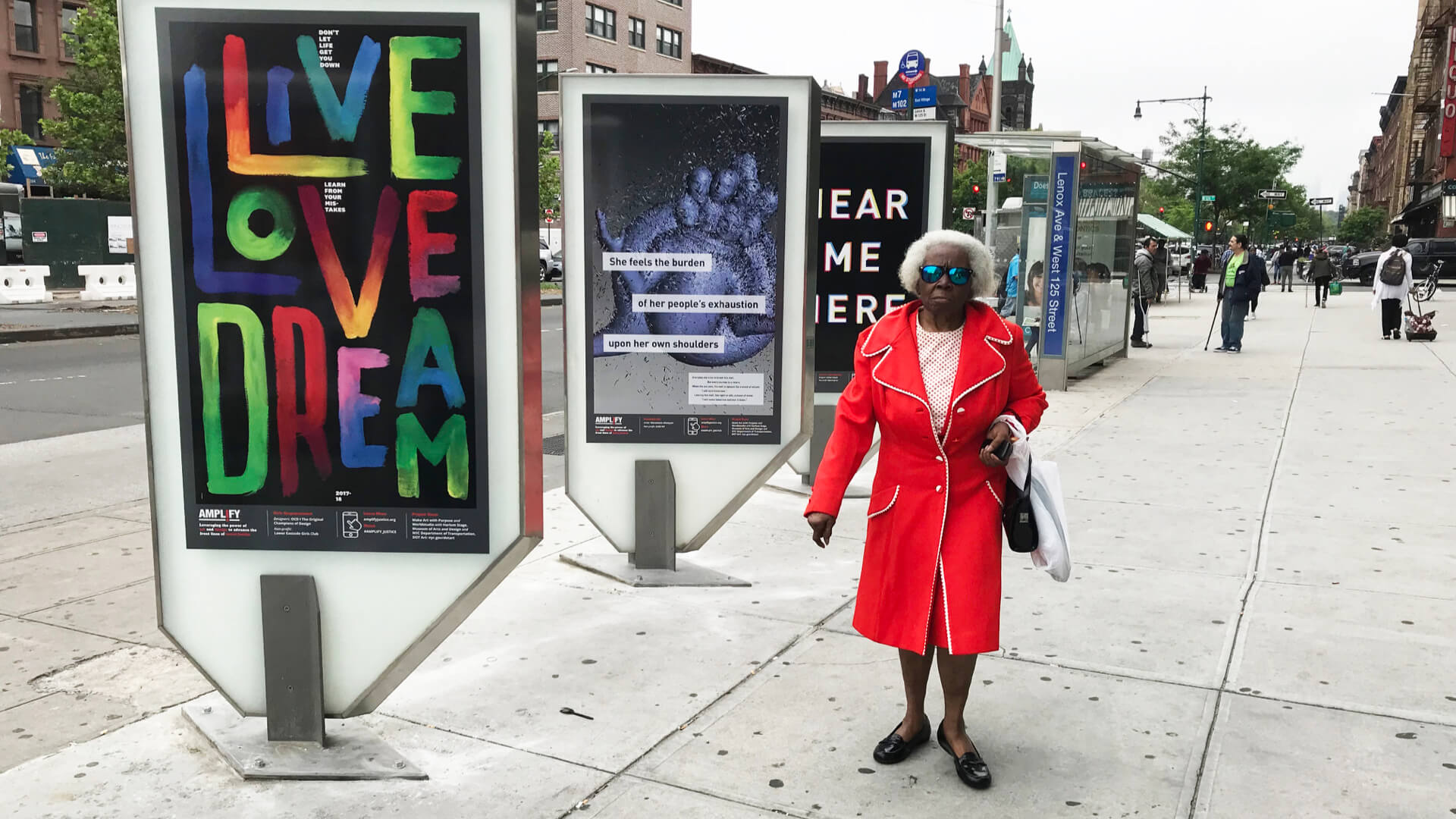 a fashionable older person is seen walking down the street lined with posters